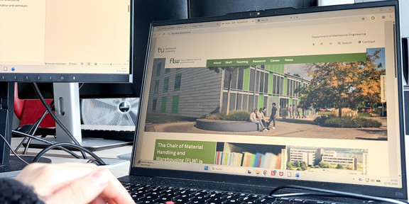 School internship administration Image detail showing the author's hand typing on the laptop keyboard. The display shows the office building of the Logistics Campus on the homepage of the FLW chair.